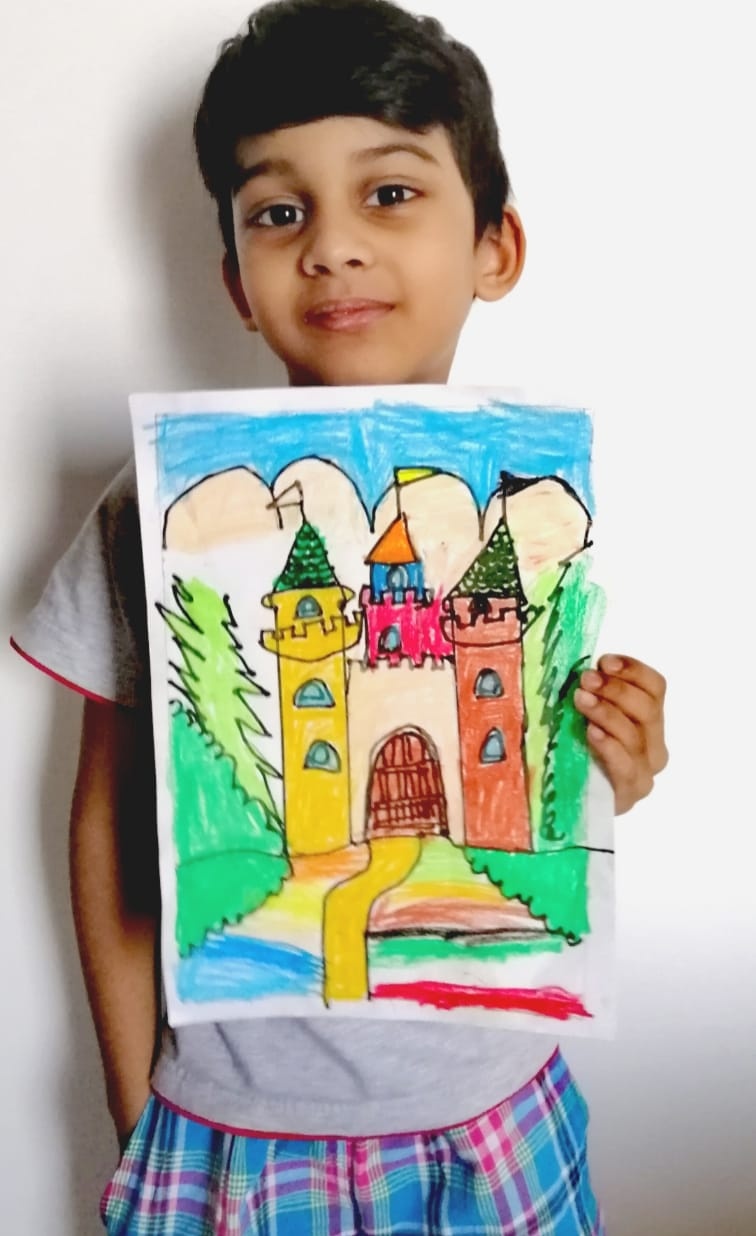 A boy holding up his colorful crayon drawing of a castle