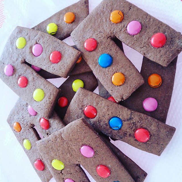 A plate of homemade chocolate cookies decorated with colorful candy buttons