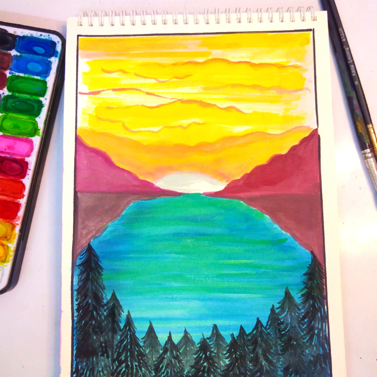 A watercolor painting of a sunset over mountains and a lake, with a paint palette alongside